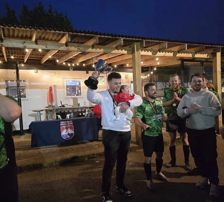 Founder lifting the league title trophy at the clubhouse